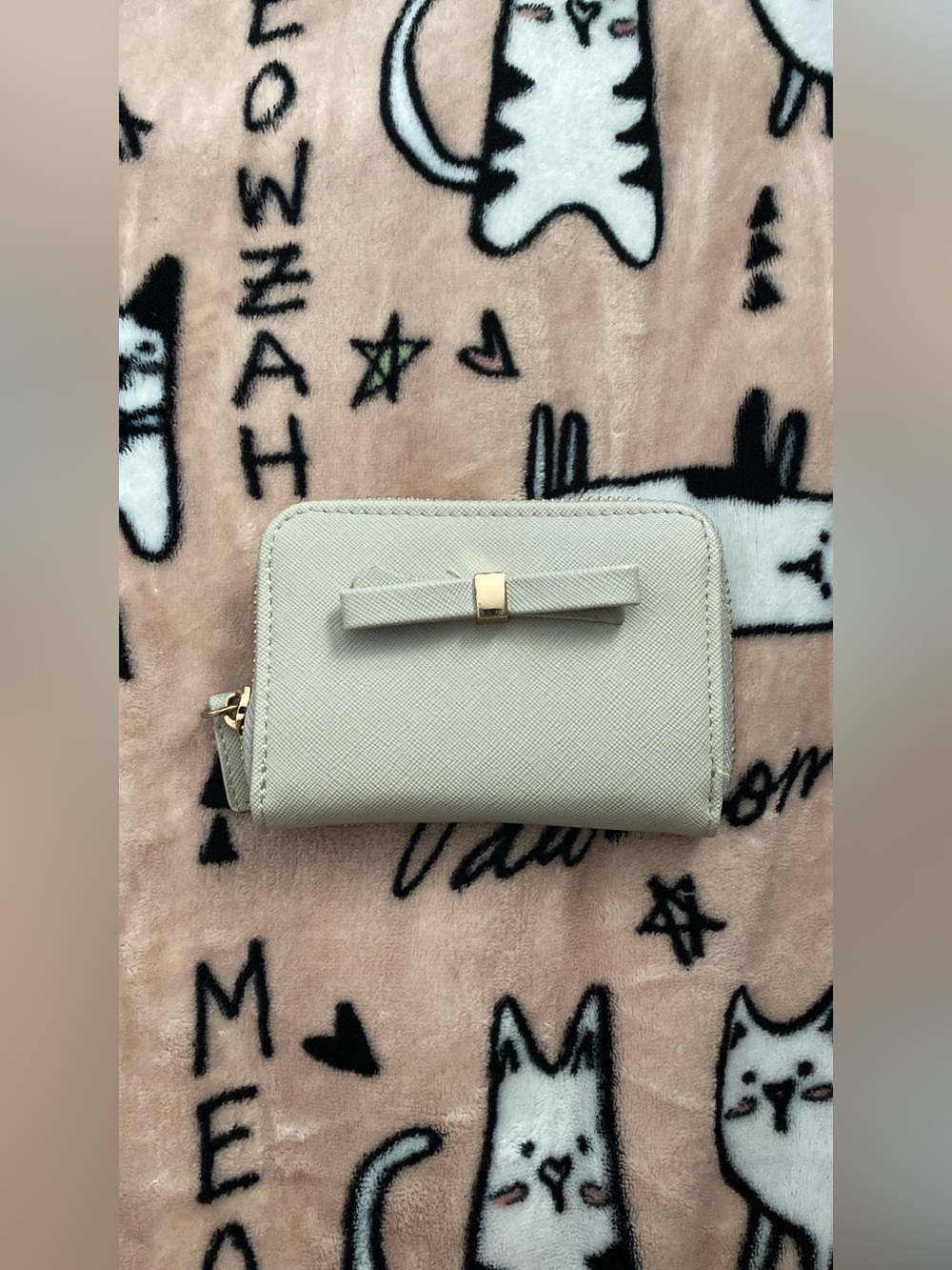 Grey small wallet with gold hardware.
